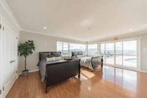 Bedroom with two beds that leads out to the pool patio at American Recovery Center (ARC)