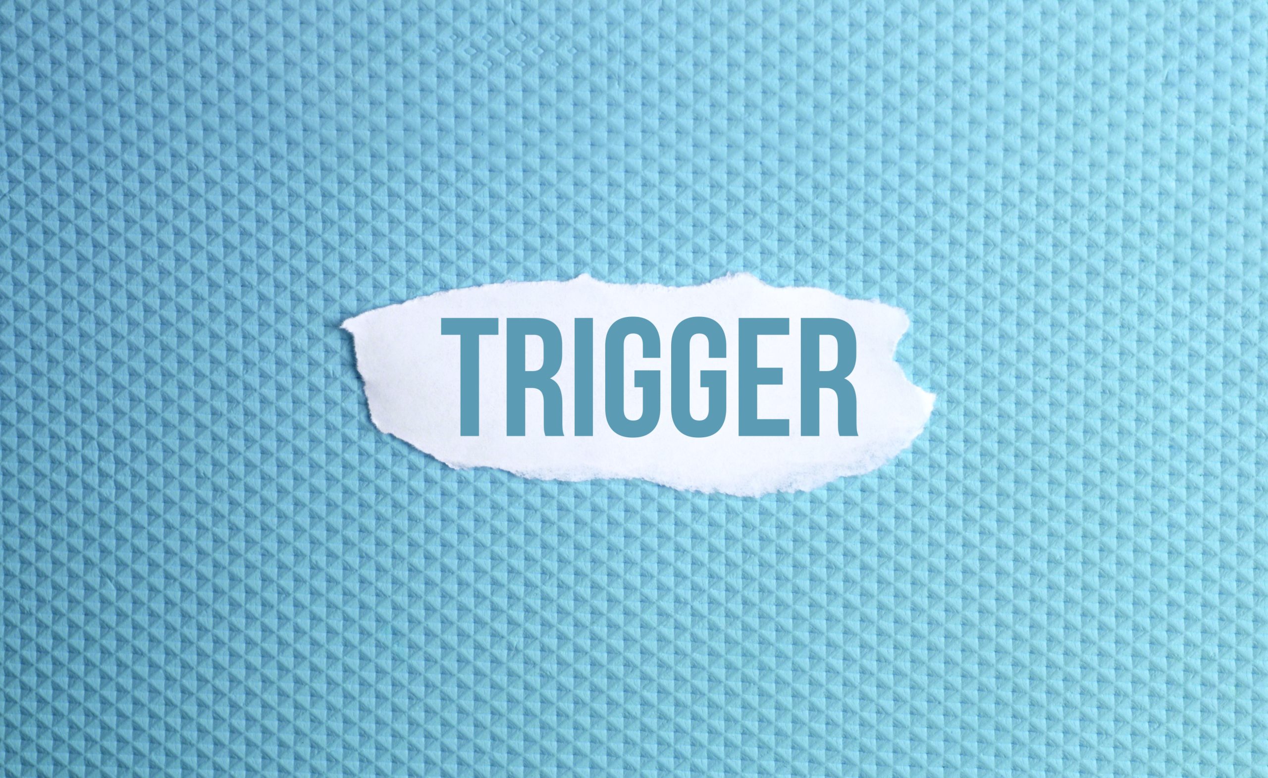 torn paper with the word "trigger" on it, representing common relapse triggers.