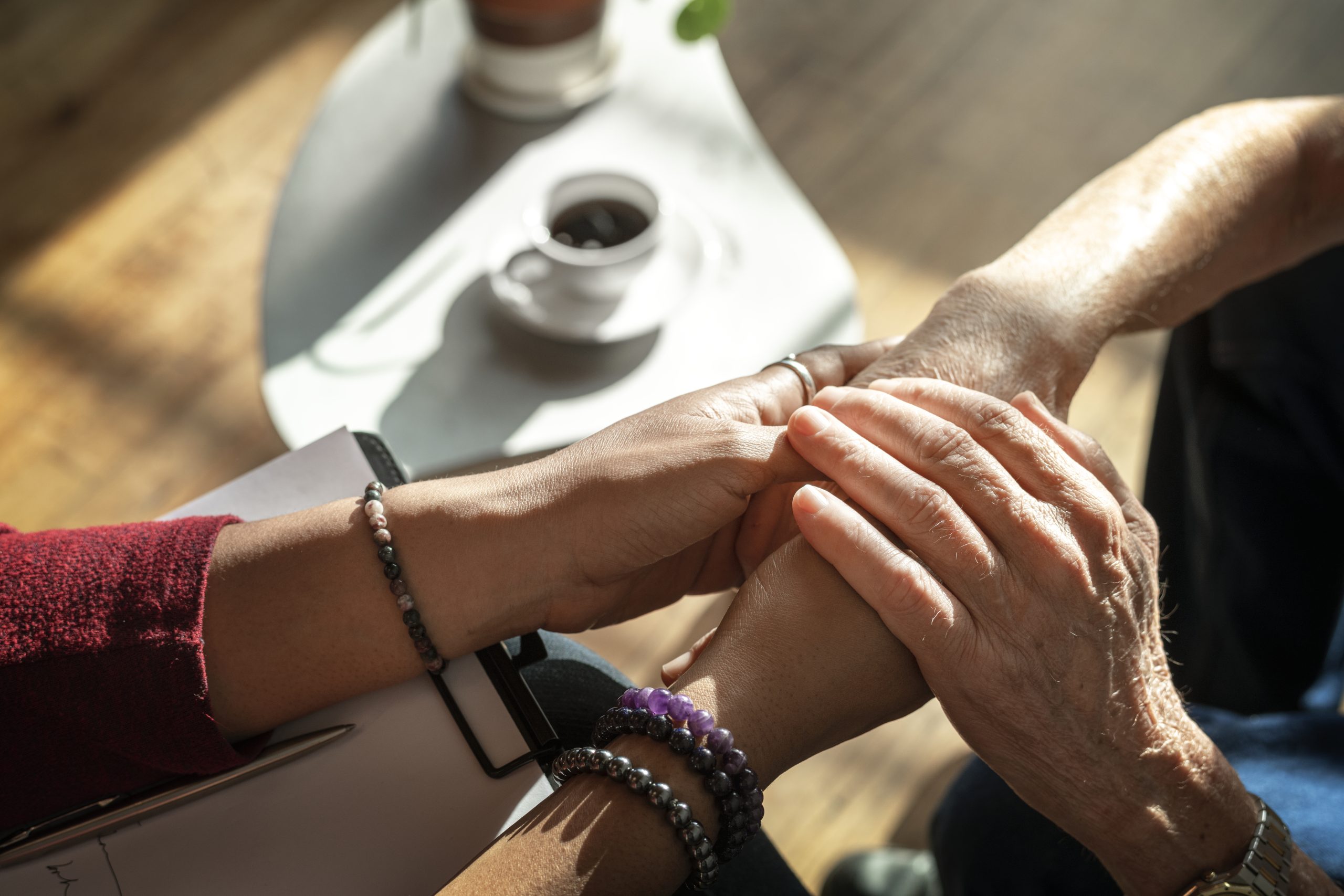 therapist supporting patient by holding their hands through a dbt chain analysis session