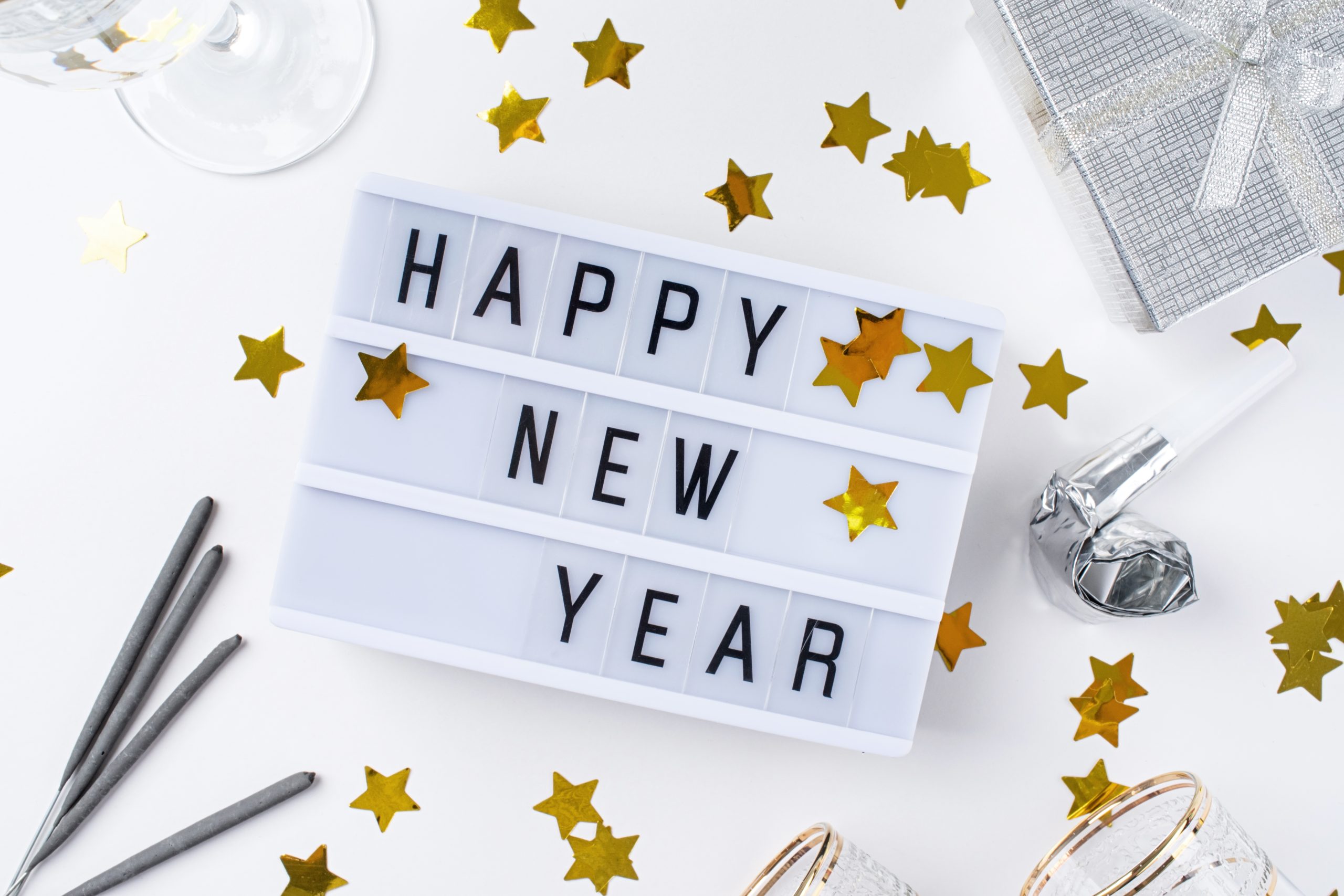 "Happy New Year" displayed on a lightbox with festive decorations surrounding it, representing a sober New Year's Eve