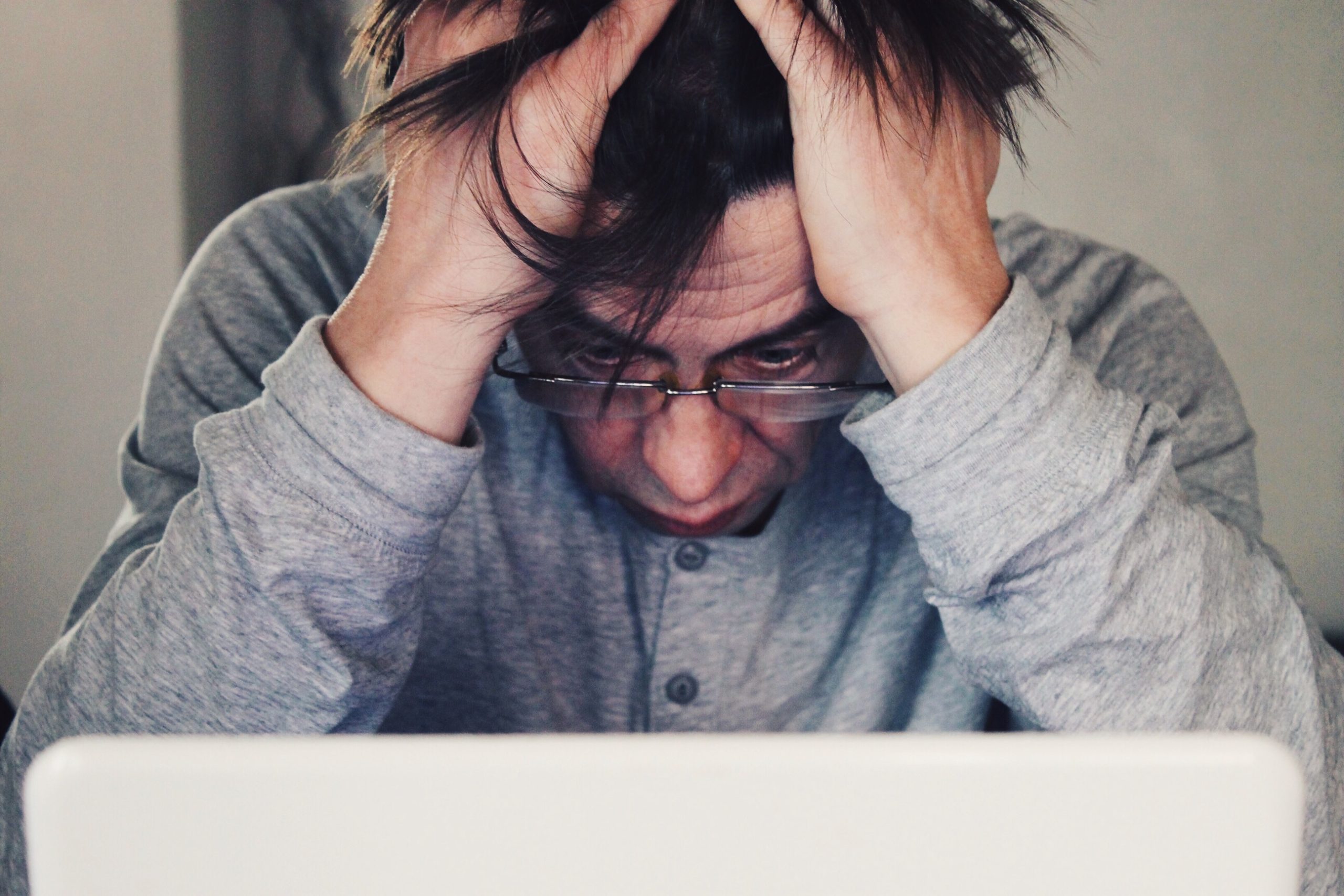 a stressed out man staring at his computer wondering how to find the right dual diagnosis treatment centers