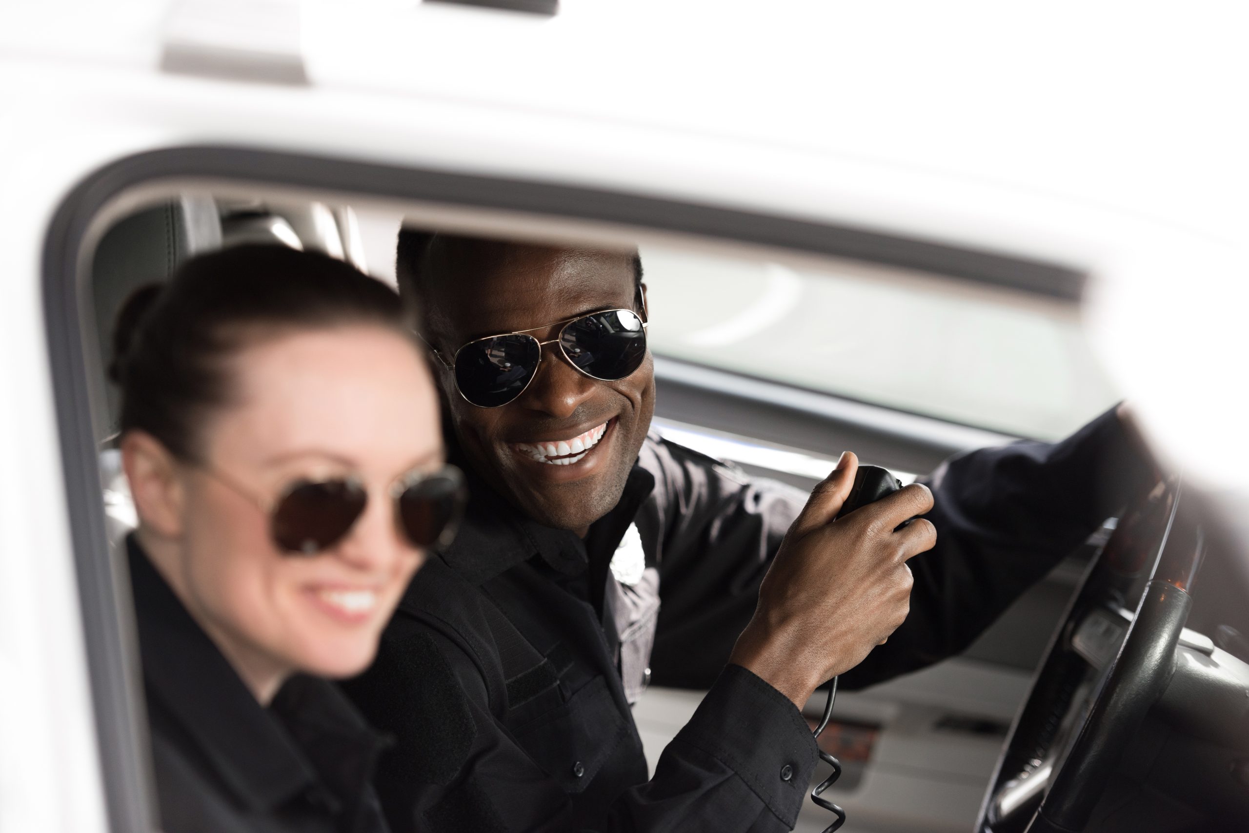 Two police officers smiling in a car, celebrating Law Enforcement Appreciation Day