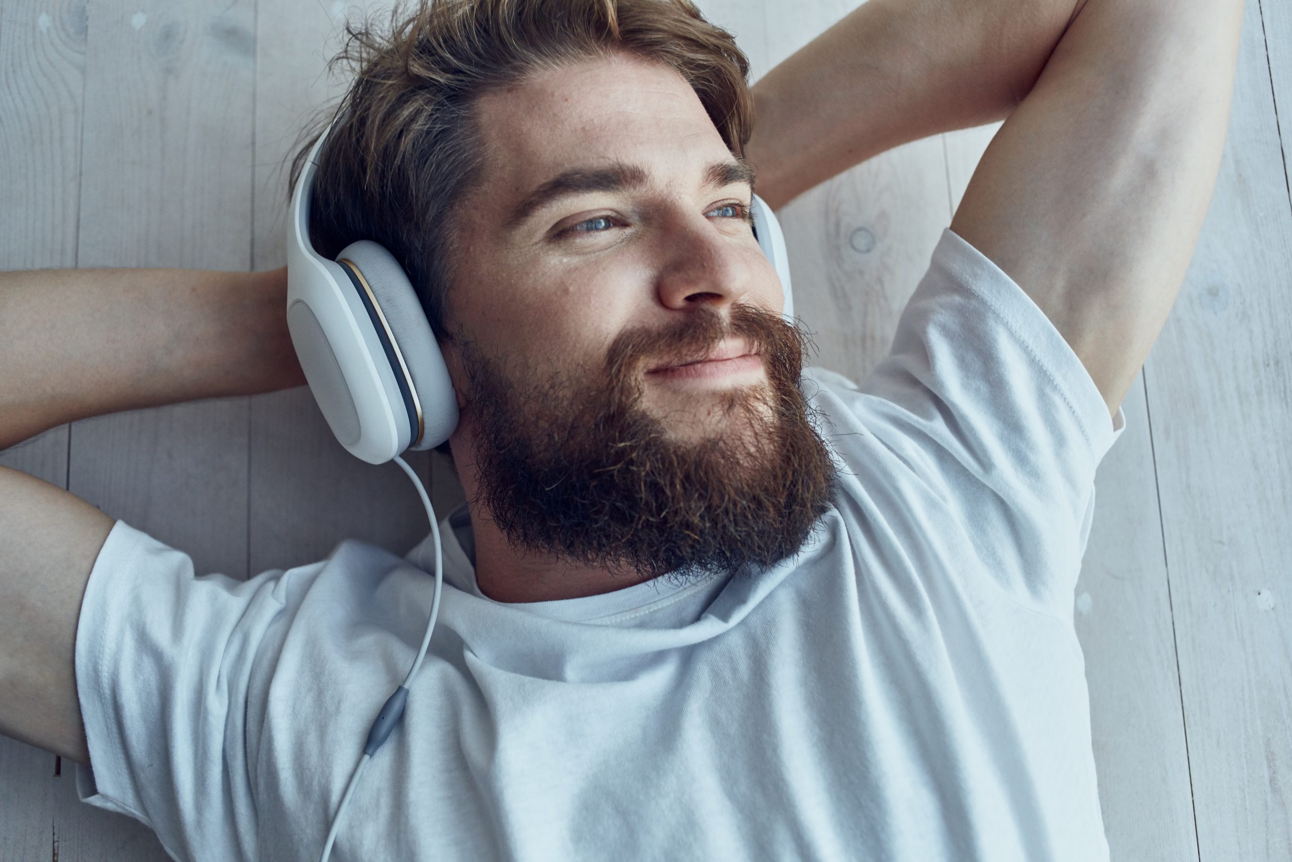 bearded man listening to addiction songs through his headphones