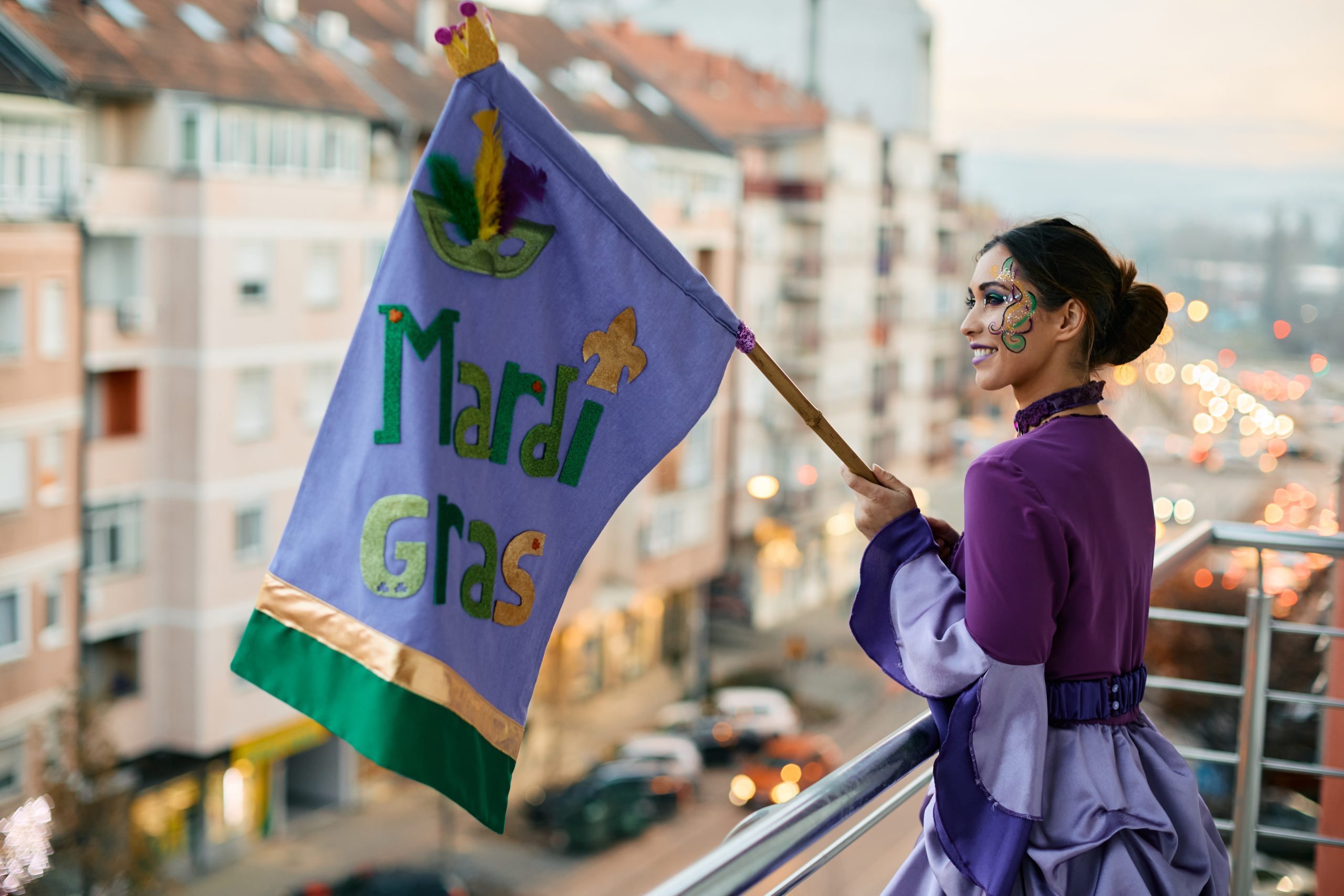 a young woman in costume holding a Mardi Gras flag, celebrating her first sober Mardi Gras