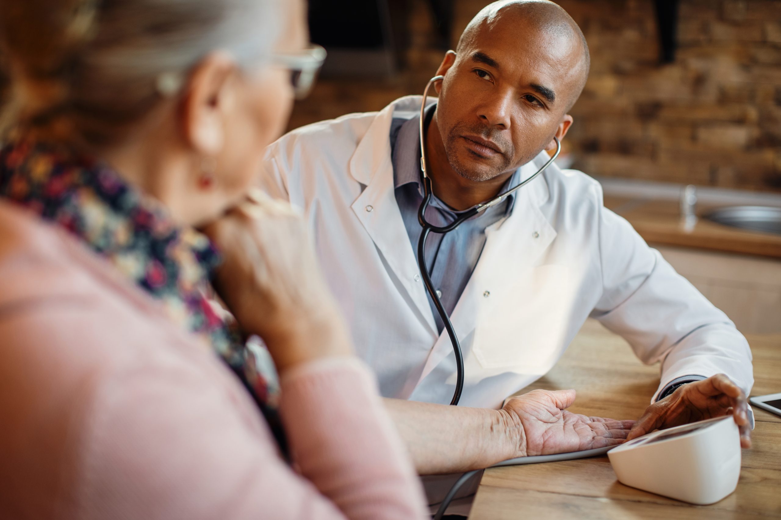 doctor measuring a senior patient's blood pressure after she asked "does medicare cover rehab?"