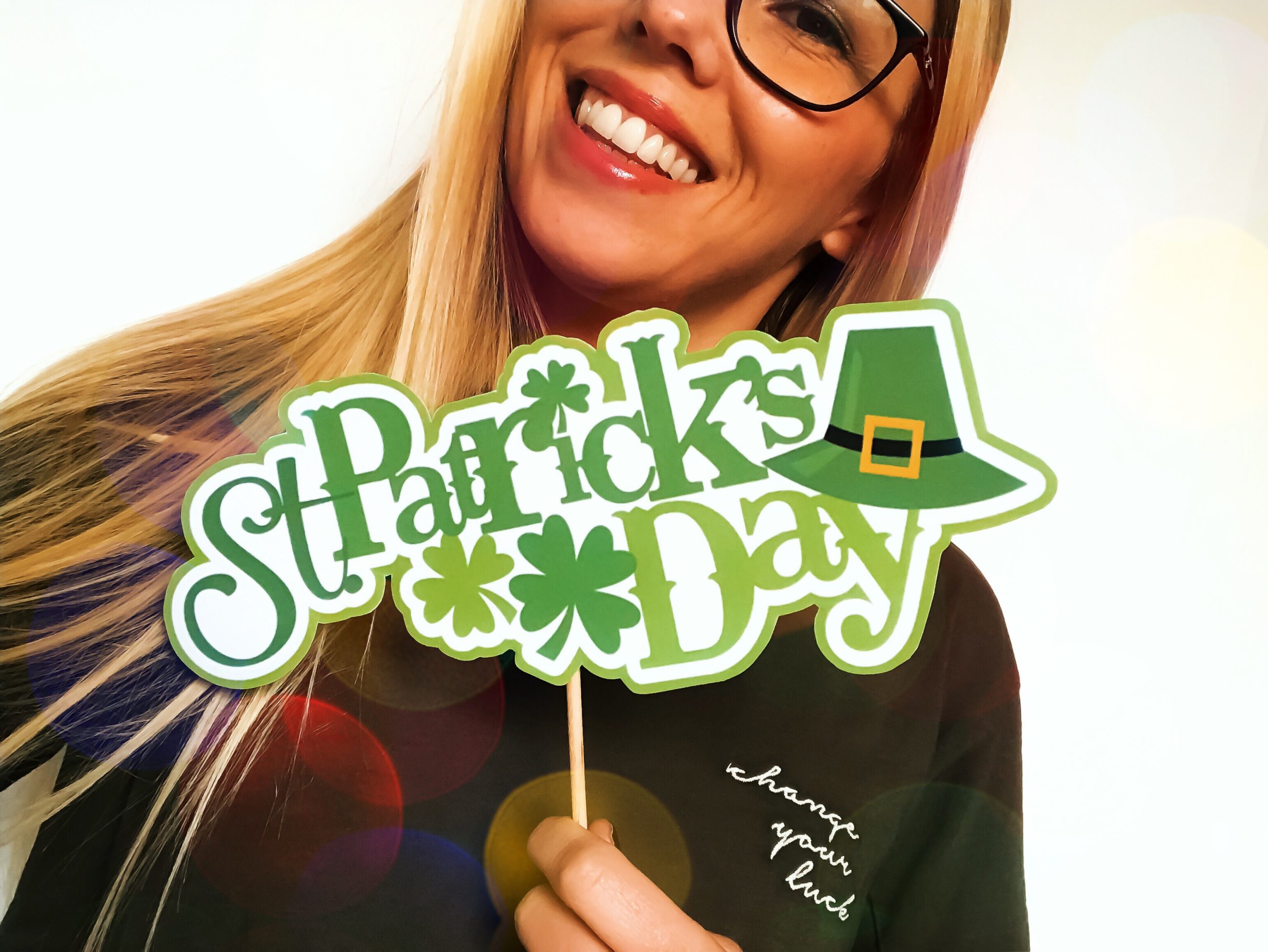 a woman holding a St. Patrick's Day sign as she is celebrating a sober St. Patrick's Day