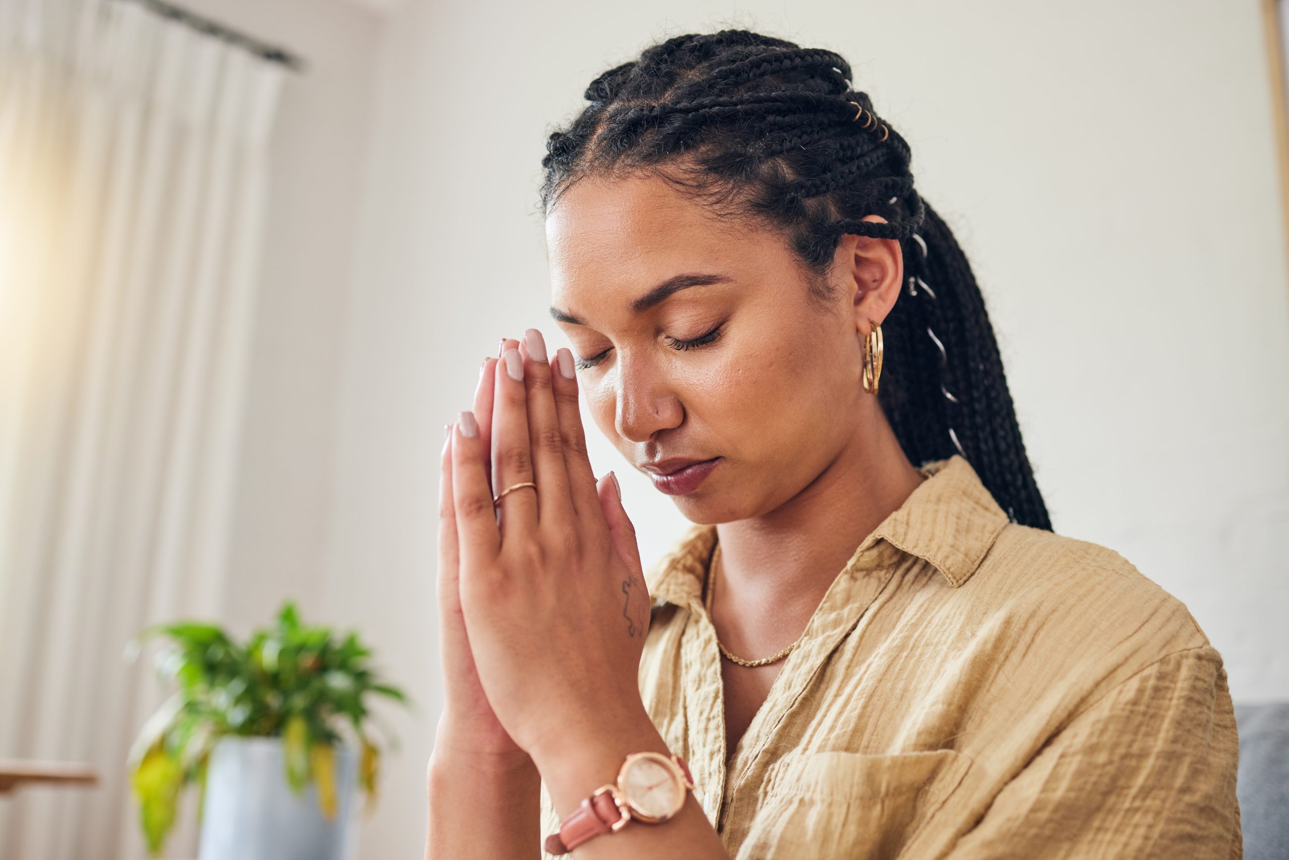 a woman praying in her living room, using religion and addiction