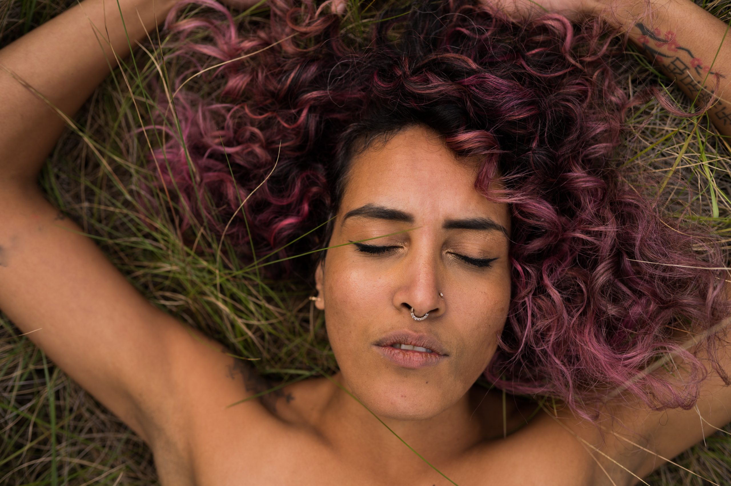 a woman lying on the grass while doing somatic experiencing therapy