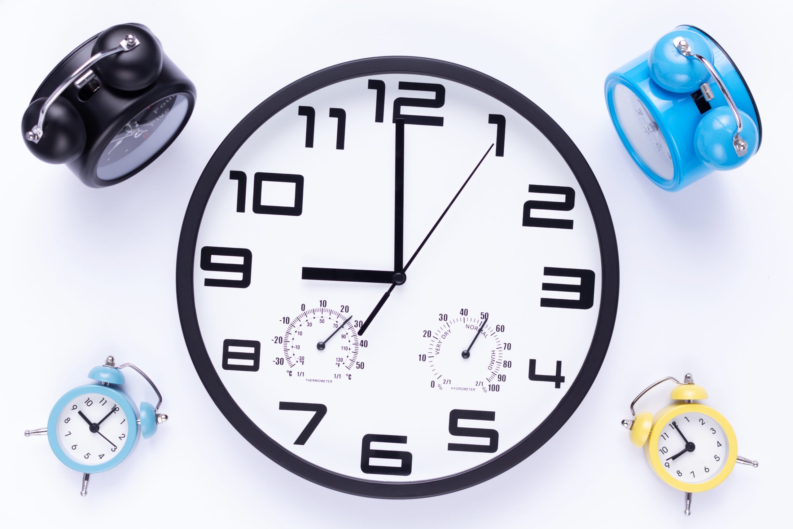 a wall clock surrounded by alarm clocks representing the question "how long does it take to sober up?"