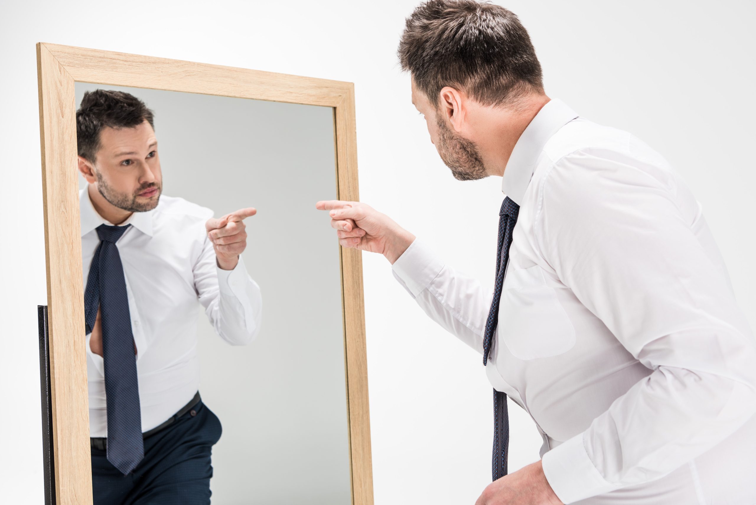 a man pointing to himself in the mirror begging the question "can drugs cause narcissism"