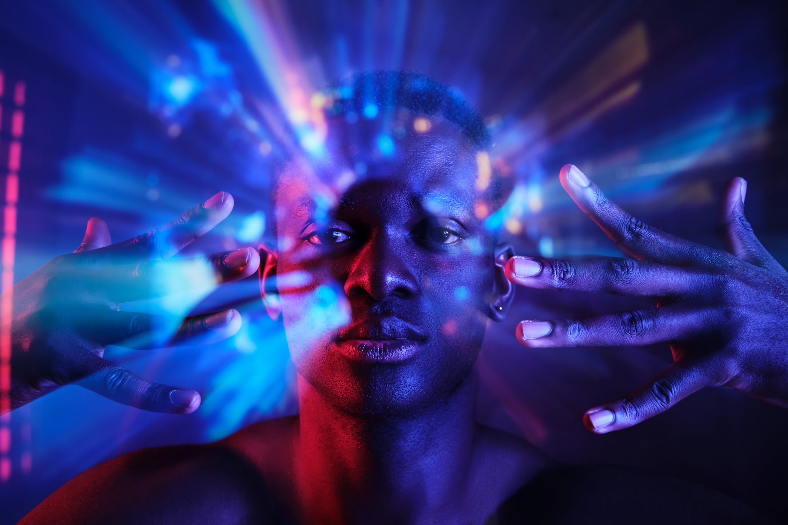 a man holding his hands near his face in neon lights while experiencing salvia divinorum side effects