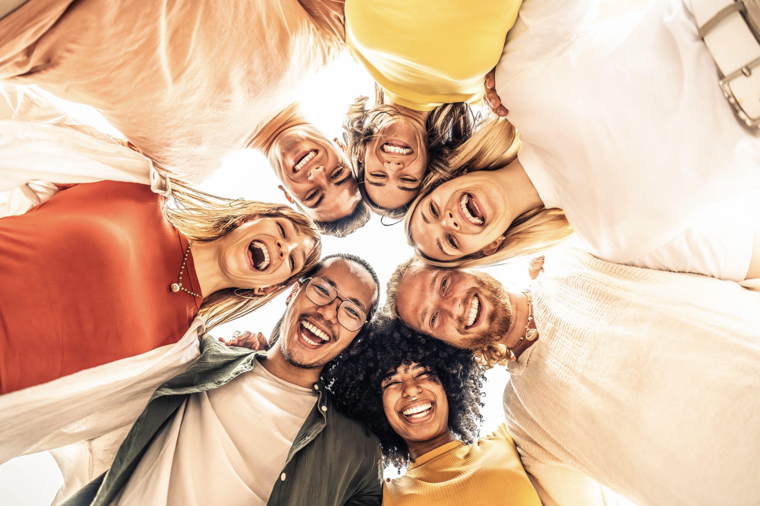 people in a circle smiling as a sing of friendship in recovery