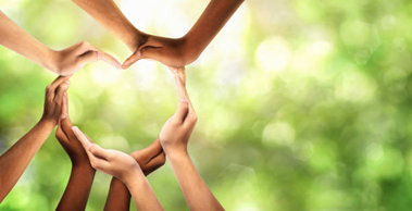 People forming a heart with their hands against a green background in celebration of National Sober Day