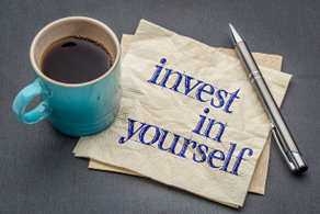 the words "invest in yourself" written on a napkin, emphasizing the importance of Self-Improvement Month