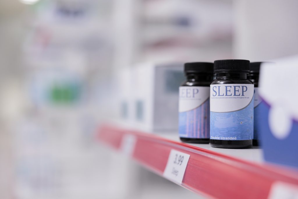 sleeping pills on a store shelf which begs the question "can you take sleeping pills with Nyquil?"